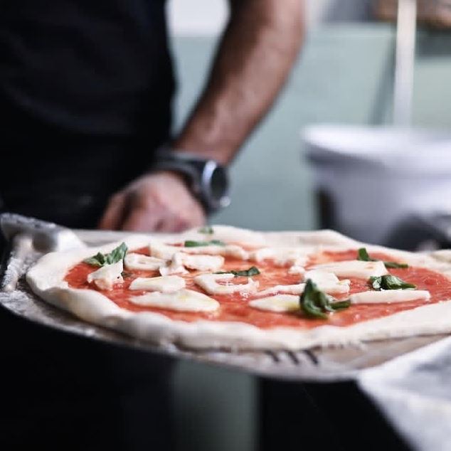 Pizza going into the oven